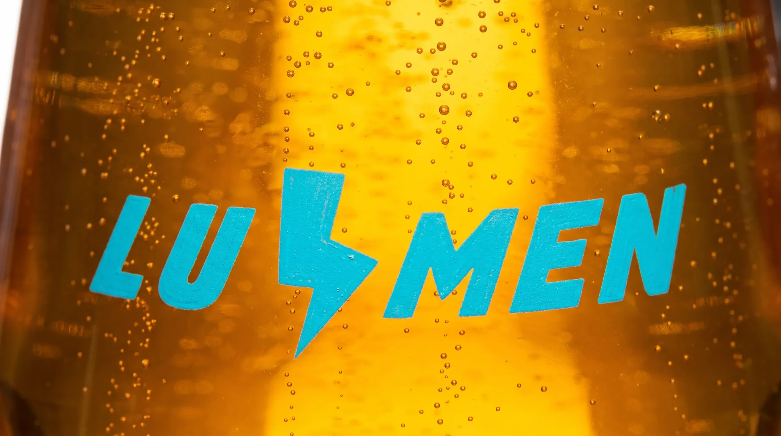 Macro of a lager with rising carbonation and condensation, beer photography