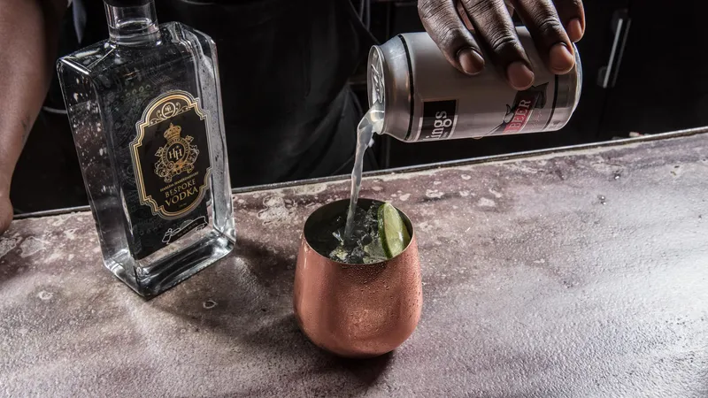 Bartender pouring a Moscow Mule with HH Bespoke Spirits at the bar