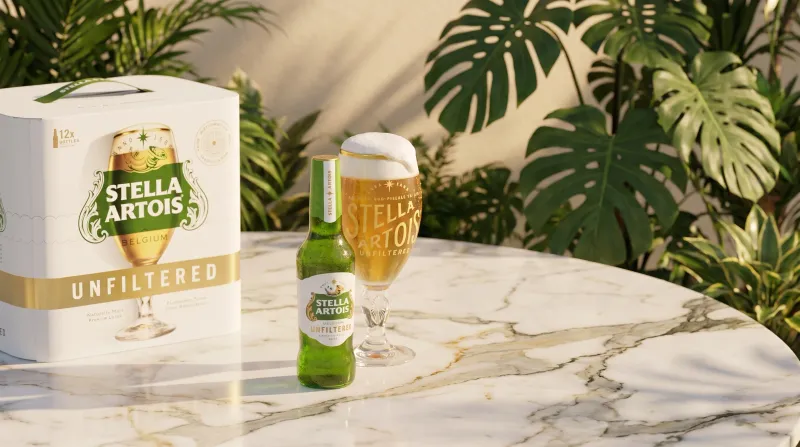 Stella Artois Unfiltered bottle, chalice, and pack on a marble table, beer advertising photography